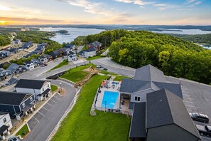 A residential area with houses, a swimming pool, and a view of a lake. - 9BR Table Rock Lake Lodge w/ Hot Tub & Game Room • Near SDC (Branson)