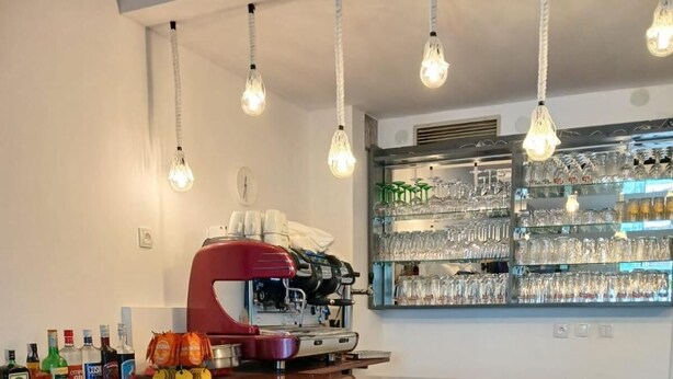 Una cocina con barra, máquina de café y una trona para bebé.