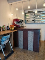 Una cucina con angolo bar, una macchina per caffè e un seggiolone per bambini.