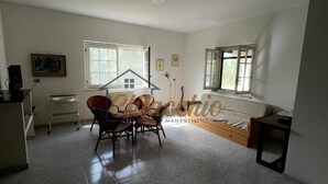Una habitación amplia con un gran ventanal, una cama, un escritorio y una silla.