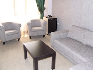 Una sala de estar con un sofá, dos sillones y una mesa de centro.