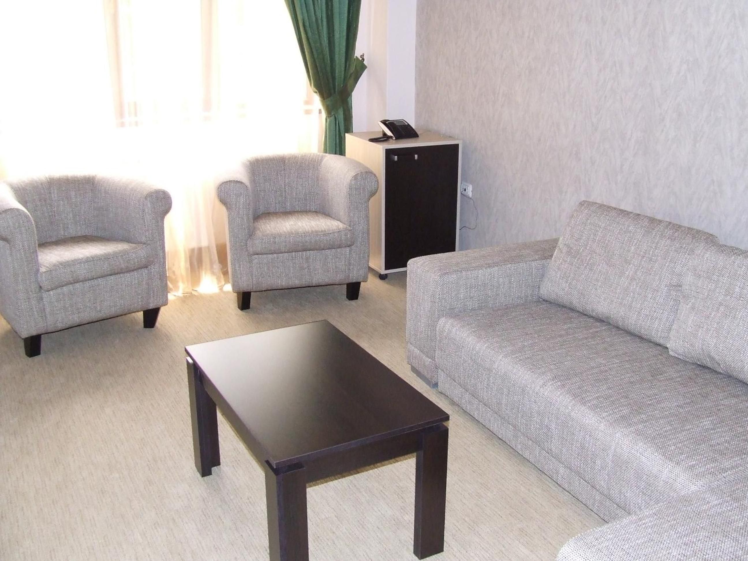A living room with a sofa, two armchairs, and a coffee table.