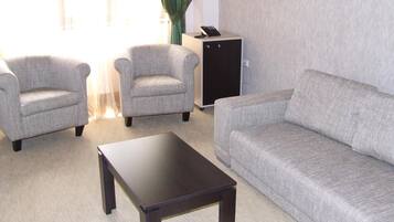 A living room with a sofa, two armchairs, and a coffee table.