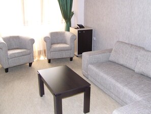A living room with a sofa, two armchairs, and a coffee table. - Hotel Davos (Deva)