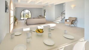 A spacious living area with a large dining table set for four, a sofa, and a wicker chair. - Luxurious home in Trequanda with house a panoramic view (Trequanda)