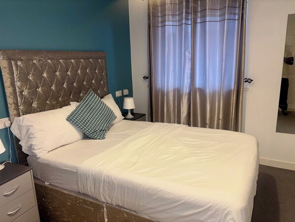 A neatly made bed with white linens, a tufted headboard, and a patterned pillow. - Peaceful Urban Retreat in Wolverhampton City (Wolverhampton)