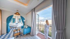 Une chambre d’hôtel moderne avec un sol à carreaux, un balcon offrant une vue, une grande fenêtre et une salle de bain avec baignoire.