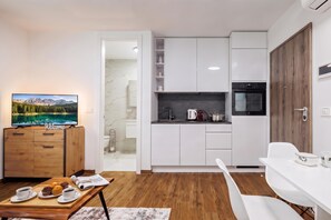 A modern kitchen with white cabinets, a built-in oven, and a coffee maker. - 1 BR City Apartment Adialuxe S5, Rijeka, Croatia (Rijeka)