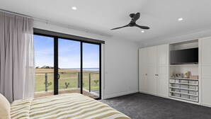 A bedroom with a bed, a ceiling fan, a TV, and a view of the outdoors. - Family sized home or couples retreat with plenty of space with spectacular views (Portarlington)