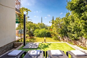A patio with outdoor seating and a view of a garden and distant landscape. - Seaview Apartment With Jacuzzi Ivano, Novi Vinodolski, Croatia (Novi Vinodolski)