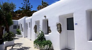 A row of white buildings with doors and windows, some with plants in front. - Paradise Beach Resort - Adults Only (Mykonos)