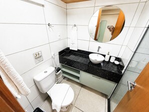 A bathroom with a toilet, sink, mirror, and towel rack. - Hosts BR - MAX Carneiros Suítes (Tamandaré)