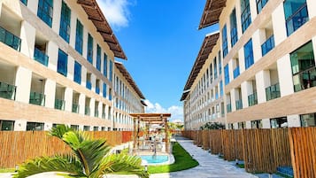 A modern hotel with a central courtyard, outdoor seating, and a swimming pool.