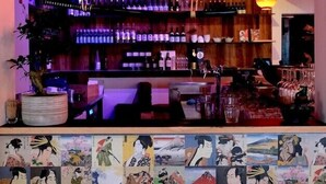 A traditional Japanese bar with wooden signage, hanging lanterns, and a wall decorated with ukiyo-e prints. - Barabas Hotel Luzern (Lucerne)