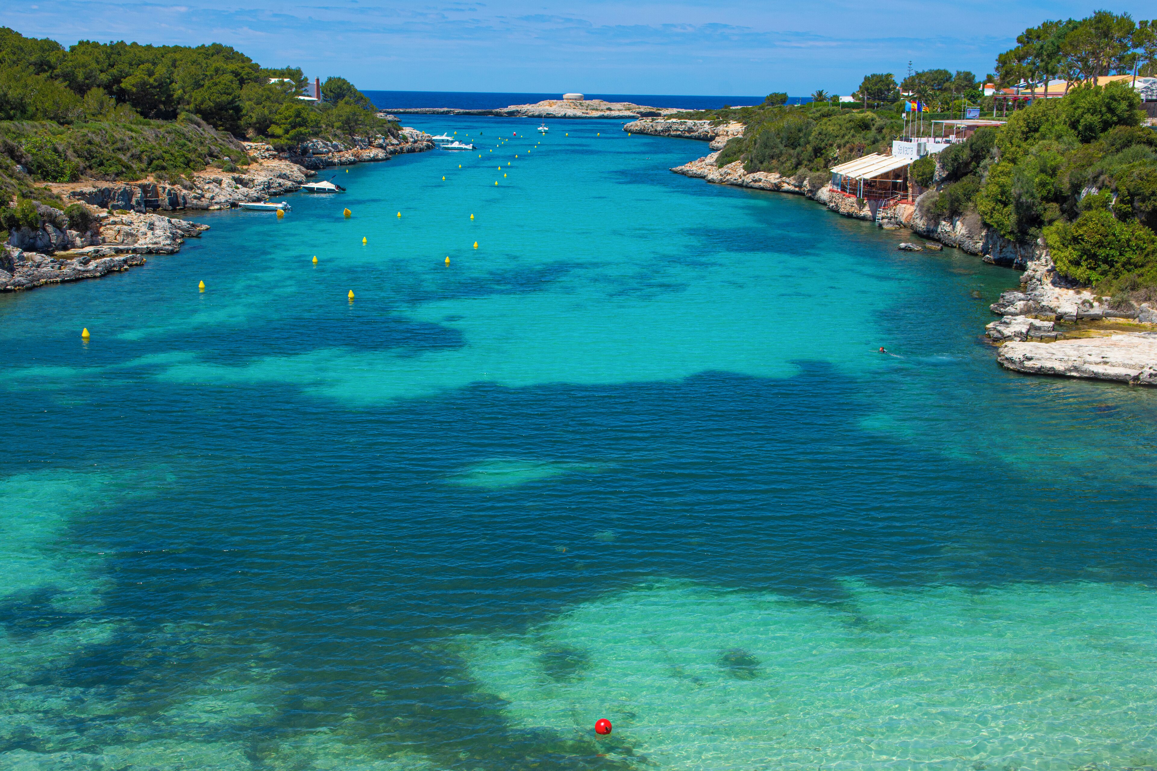 Une zone côtière caractérisée par des eaux turquoise et limpides, des rivages rocheux et une végétation luxuriante.