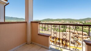 Ein Balkon mit Blick auf ein Wohngebiet und Hügel.