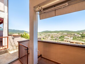 A balcony with a view of a town and hills. - Apartment Parigi by Interhome (Villasimius)