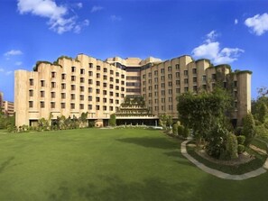 Un grande hotel a più piani con facciata simmetrica, numerose finestre e un cortile centrale con fontana.