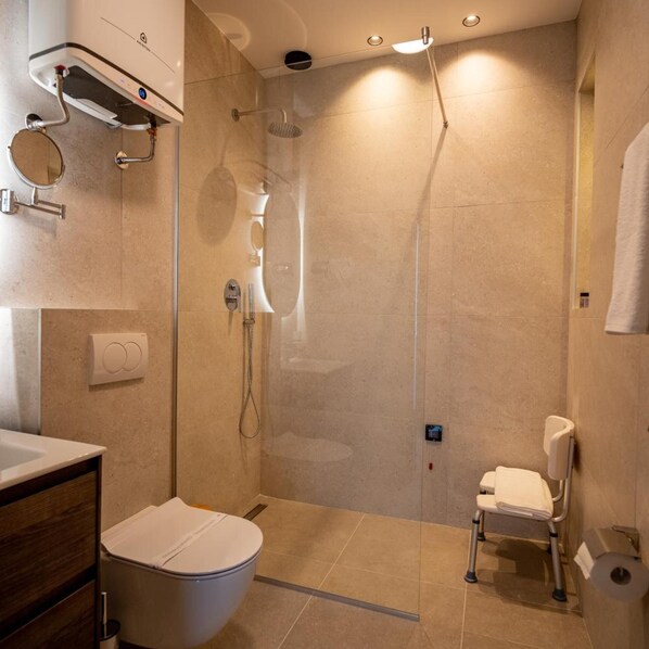 A modern bathroom with a toilet, bidet, and shower. - Aria Hotel (Mahala)
