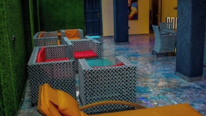 A lounge area with patterned sofas and chairs, a green wall, and a tiled floor. - Soulmate Hotels & Suites Ojodu (Lagos)