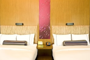 A hotel room with two beds, a nightstand with a clock and phone, and a wall with a bubble pattern. - Aloft Haidian Hotel Beijing (Beijing)