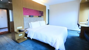 A hotel room with a bed, bedside table, and a desk with a chair. - Aloft Haidian Hotel Beijing (Beijing)