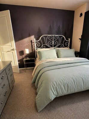 A bedroom with a bed, dresser, nightstand, lamp, and a wall with a forest mural. - 1BR, 1BA Centrally located, private, safe, quiet! Close to everything! (Denver)