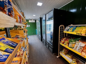 A grocery store aisle with shelves stocked with snacks and beverages. - Hosts BR - Viva Praia do Futuro (Fortaleza)