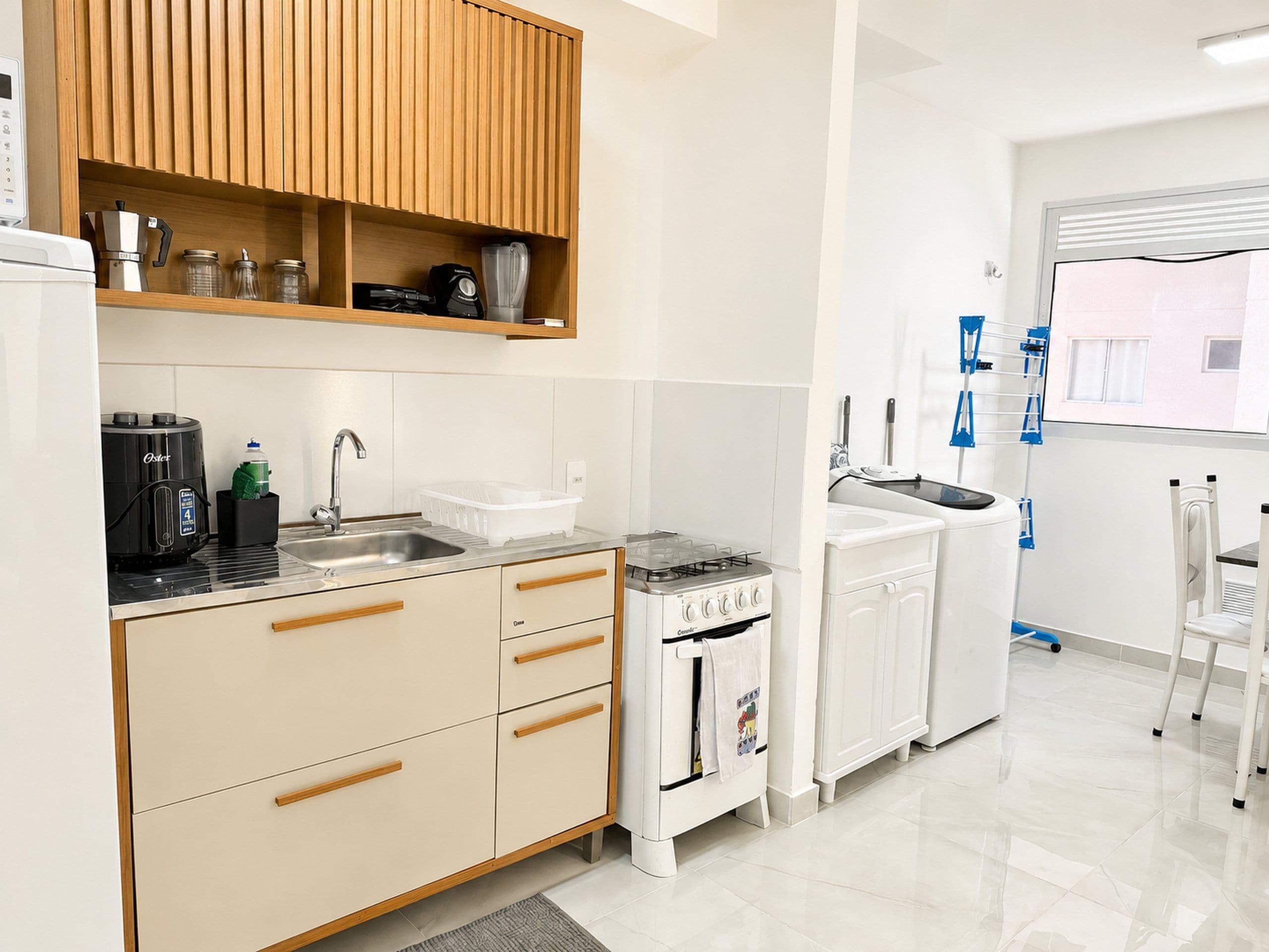 A modern kitchen with a built-in oven, a coffee machine, and a sink.