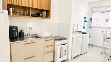 A modern kitchen with a built-in oven, a coffee machine, and a sink.