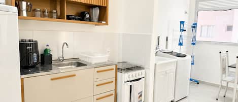 Una cocina moderna con horno integrado, cafetera y lavabo.