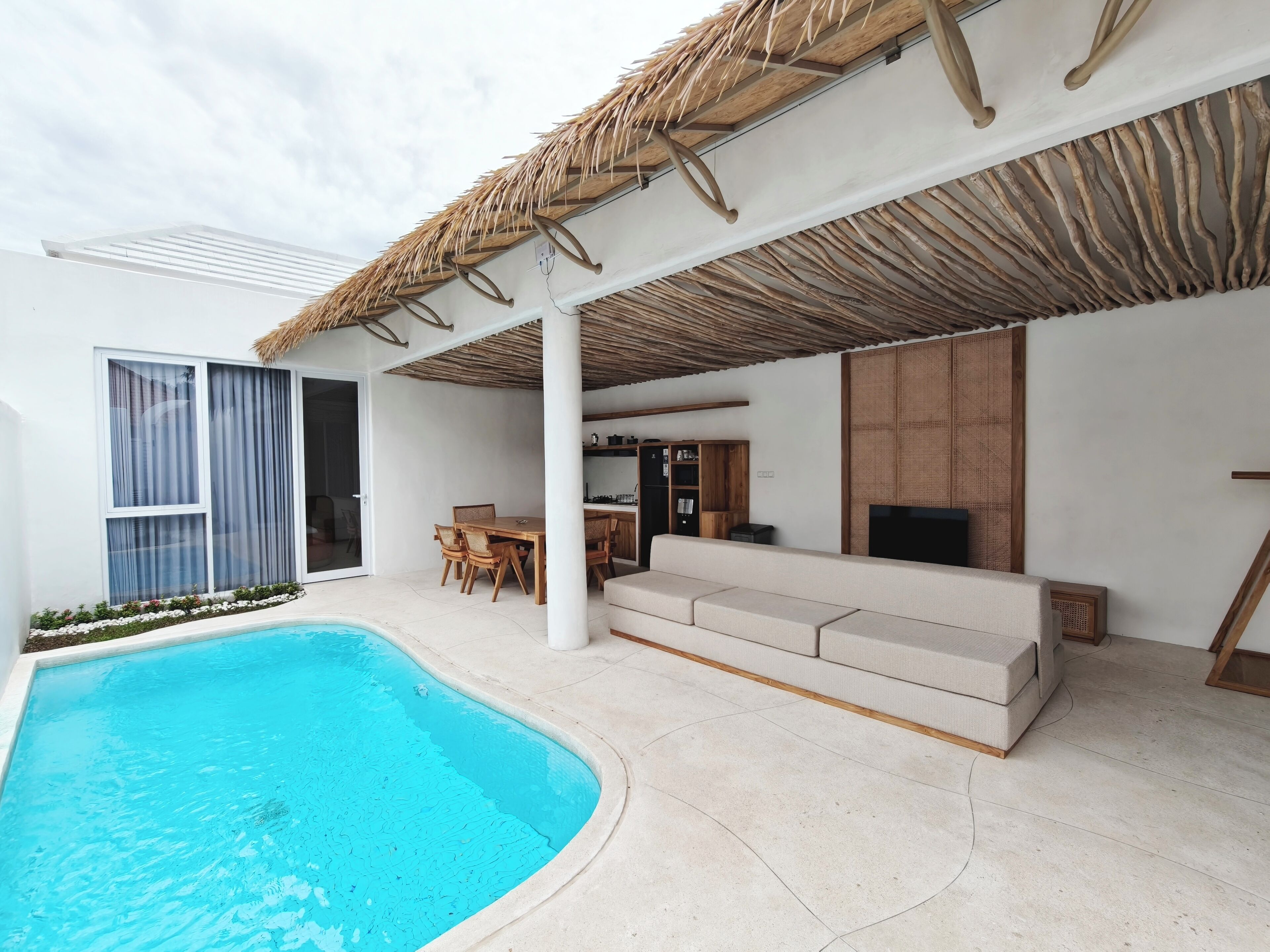 Un espacio al aire libre moderno con piscina, comedor y zona de estar.