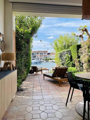 An outdoor patio with hexagonal tiles, a pool, and a view of buildings and boats. - Beautiful house for 4 people with WiFi  et  11.50 m mooring (PORT GRIMAUD)