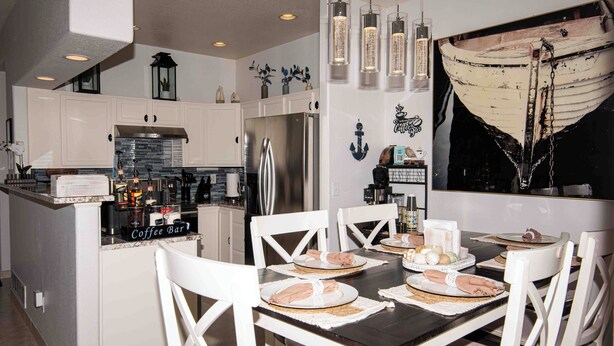 A modern kitchen with white cabinetry, a stainless steel refrigerator, and a coffee bar. - Spacious 4-bedroom townhome in tranquil Lakewood with AC (Lakewood)