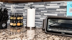 A kitchen with a Ninja air fryer, a set of knives, and spice jars on the counter. - Spacious 4-bedroom townhome in tranquil Lakewood with AC (Lakewood)