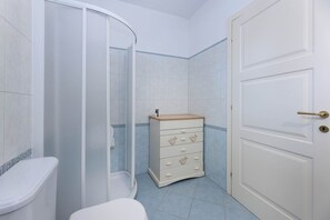 A bathroom with a shower, toilet, and a cabinet with drawers. - Sale Marino - Goelba (Capoliveri)