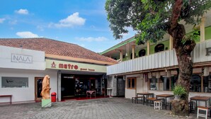 A courtyard with hexagonal paving, a guest house, and a self-photo studio. - OYO 95140 Metro Guest House (Yogyakarta)