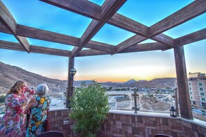 A balcony with a view of a cityscape and mountains. - La Maison Hotel (Wadi Musa)