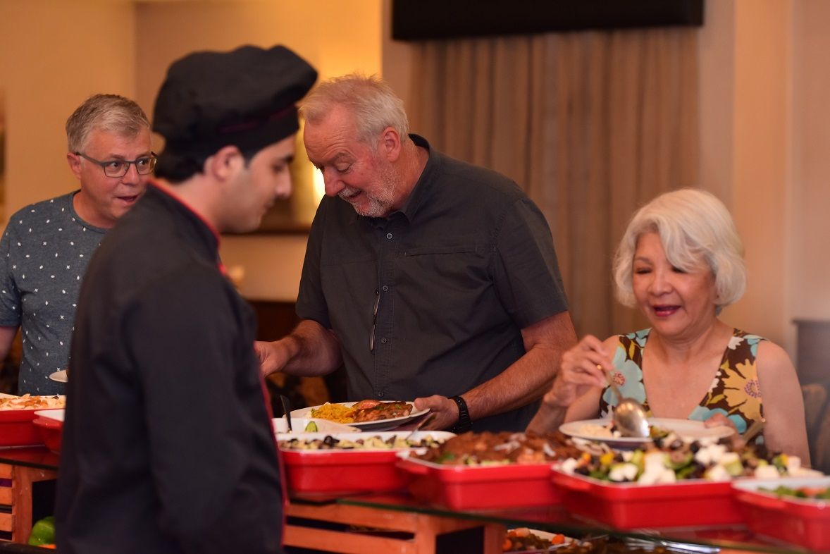 A group of people dining at a buffet with various dishes.