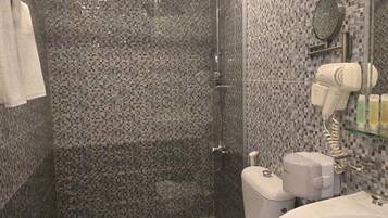 Ein Badezimmer mit Dusche, Toilette und Waschbecken.