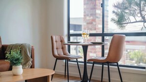 Un rincón comedor acogedor con una mesa redonda, dos sillas y una planta en maceta.