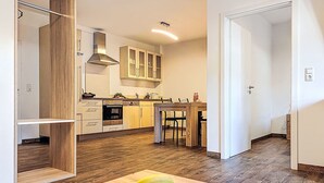 Eine moderne Küche mit Holzausstattung, einer Kochinsel und einer Obstschale auf der Arbeitsplatte.