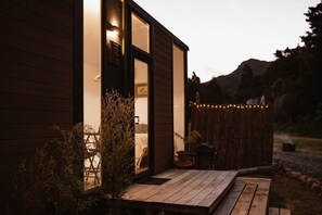 A wooden building with a deck, a door, and a window.