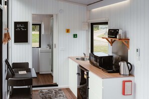 A compact kitchen with a microwave, coffee maker, and a small sink. - Omoho Stream X by Tiny Away (Kennedy Bay)