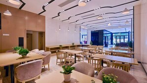 A modern dining area with wooden tables and chairs, ceiling lights, and a view of the outdoors. - Lavande International Hotel Pazhou Convention & Exhibition Center Eastxiaonan Metro Station Branch - Free Deliver Service to Guangzhou Baiyun International Airport & Free Shuttle Bus to Canton Fair Complex During Canton Fair Period (Guangzhou)