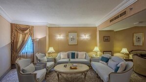 A classic hotel room with a sofa set, armchairs, a coffee table, and two lamps. - Al Shohada by Palm Rich Makkah EX - Al Shohada Hotel (Makkah)