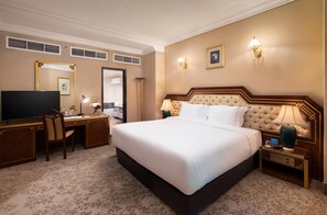 Ein Hotelzimmer mit einem großen Bett, einem Schreibtisch mit Stuhl, einem Fernseher und einem Spiegel.