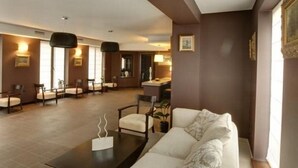 A modern living room with a sofa, chairs, a coffee table, and a dining area with chairs and a table. - 6ato Hotel Sofia (Sofia)
