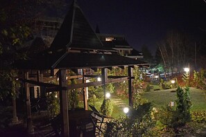 A gazebo with a roof, surrounded by greenery and a well-lit garden area. - 6ato Hotel Sofia (Sofia)