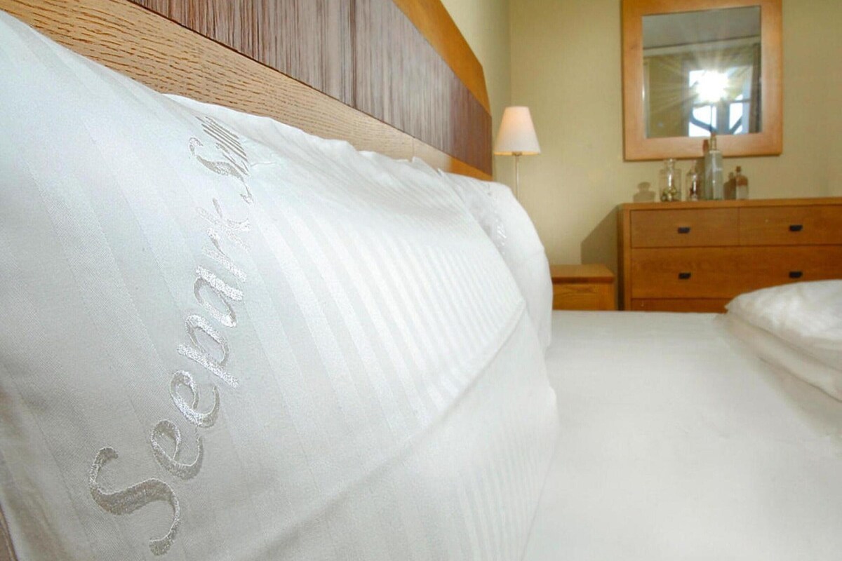A neatly made bed with a pillow labeled "Separation" in a hotel room.